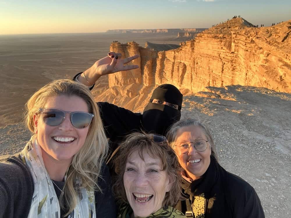 Group photo at the Edge of the World near Riyadh with dramatic desert cliffs on a Saudi Arabia itinerary