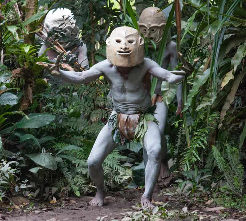 Asaro Mudman in clay mask aiming a bow during a traditional performance in Papua New Guinea