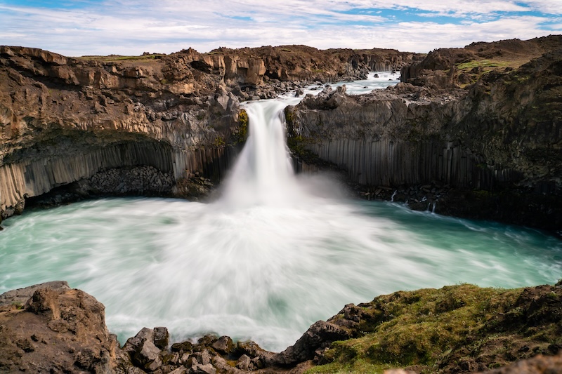 Aldeyjarfoss waterfall plunging into a turquoise pool framed by dark basalt columns in North Iceland