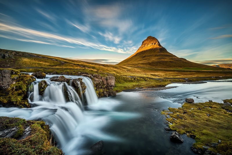 Kirkjufellsfoss waterfall cascading beside the iconic peak of Kirkjufell on Iceland's Snæfellsnes Peninsula at golden hour
