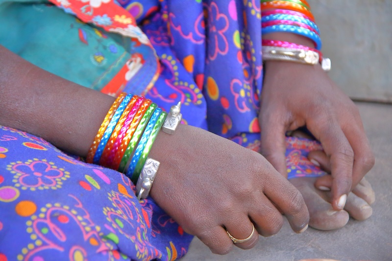 Close-up of a woman's hands from Nirona village near Bhuj, Gujarat, wearing colorful bangles and silver bracelets